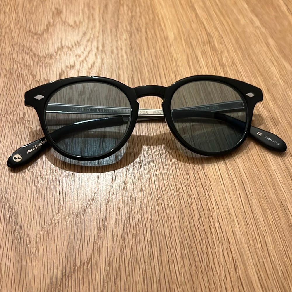 Black Garrett Leight sunglasses with blue lens